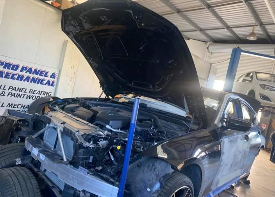 A BMW with the bonnet up in the Pro Panel and Mechanical workshop