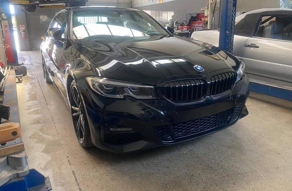 A finished black BMW M Sport in the workshop after full body work
