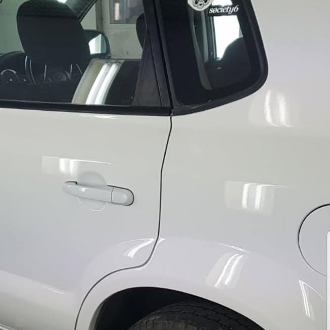 A white SUV door and rear quarter after dent repair