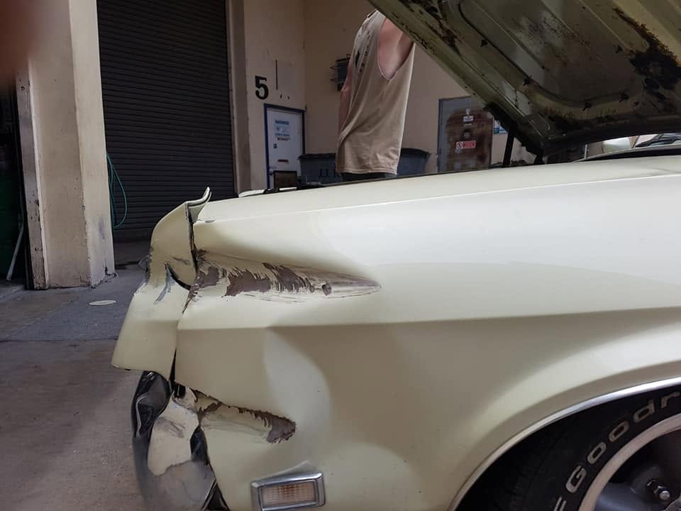Front guard damage on a classic car before repair