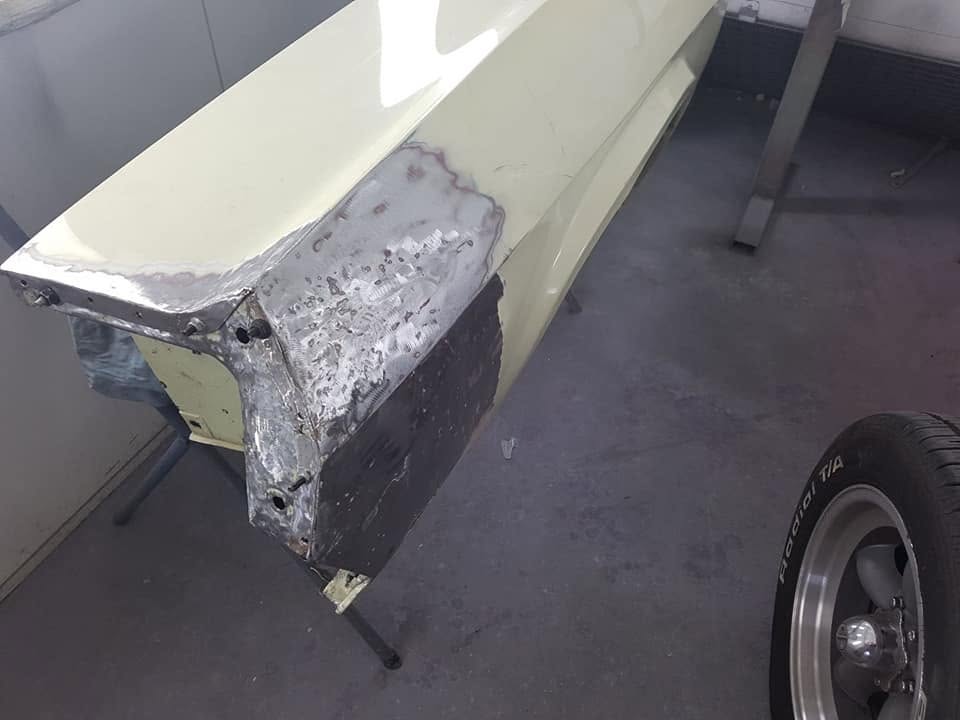 Hand-formed metal repair on the front guard of a 1960s classic car