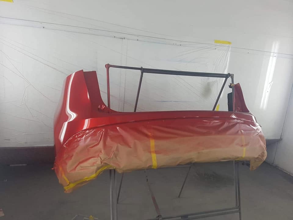 A red panel on a stand in the spray booth