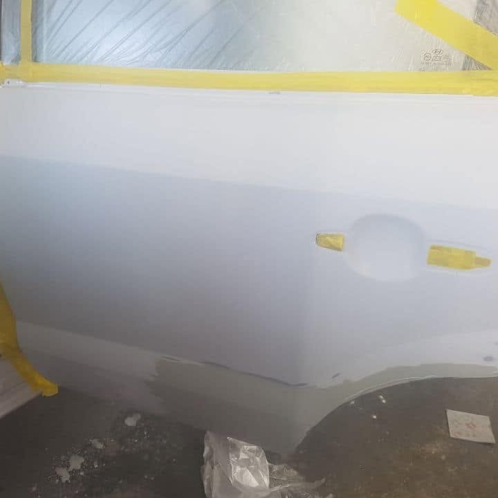 A car masked along the side for spray painting