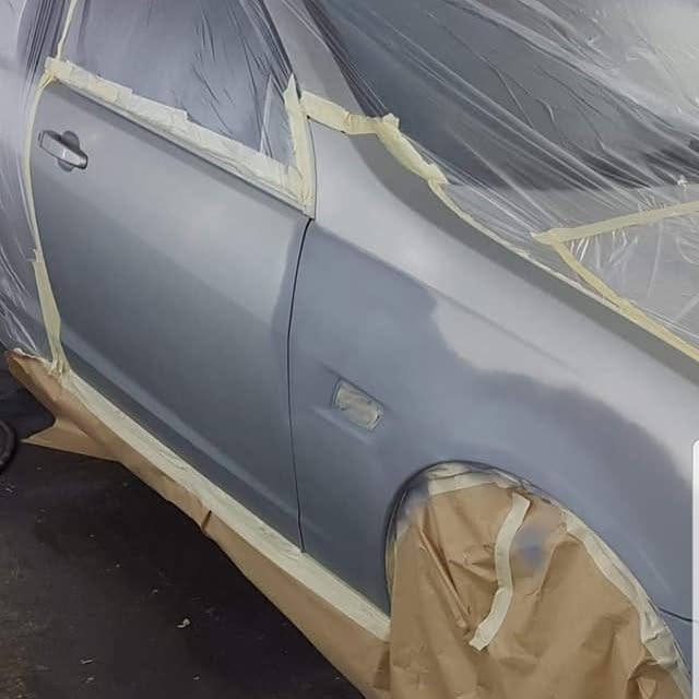 A silver car masked up in the booth