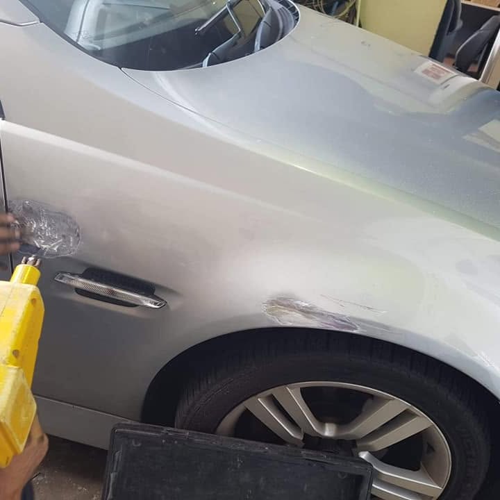 A silver car with the rear quarter and door finished